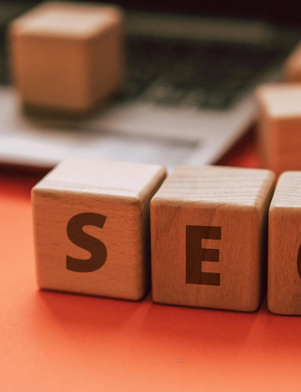 SEO wooden letter blocks next to laptop