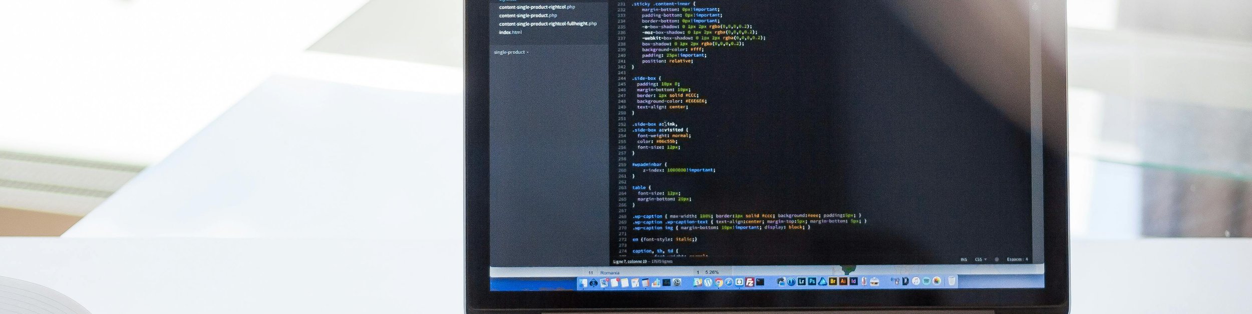 web design workspace with laptop, notebook, and phone on desk